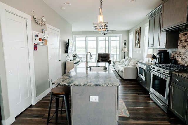 210 Leeward Way, Ottawa, IL 61350 - kitchen with appliances with stainless steel finishes, open floor plan, a breakfast bar, decorative backsplash, and light stone countertops