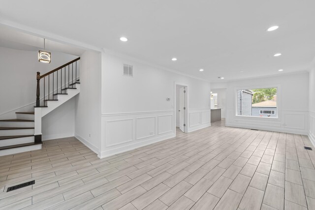 3002 Wesley Ave, Berwyn, IL 60402 - unfurnished living room with a decorative wall, stairs, recessed lighting, wainscoting, and crown molding