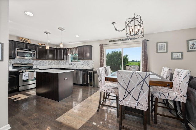 1680 Rockport Rd, Hampshire, IL 60140 - kitchen with appliances with stainless steel finishes, a center island, backsplash, light countertops, and a chandelier
