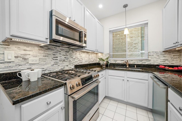 535 W Eugenie St Unit 1, Chicago, IL 60614 - kitchen with stainless steel appliances, light tile patterned floors, tasteful backsplash, pendant lighting, and dark stone countertops