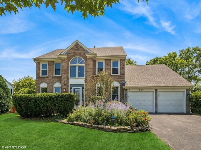 627 Williams Way, Vernon Hills, IL 60061 - view of front of property with a garage, a front yard, asphalt driveway, brick siding, and a shingled roof