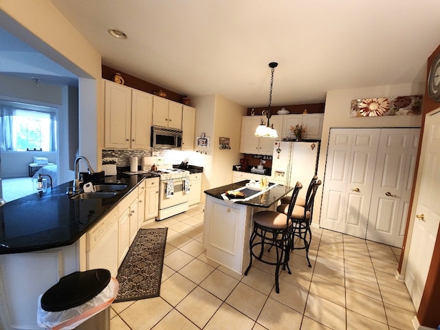 2510 Lorraine Cir, Geneva, IL 60134 - kitchen featuring white appliances, a breakfast bar, dark countertops, light tile patterned floors, and hanging light fixtures
