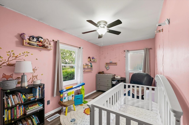 2009 E Michigan Ave, Urbana, IL 61802 - bedroom featuring a crib, wood finished floors, and ceiling fan