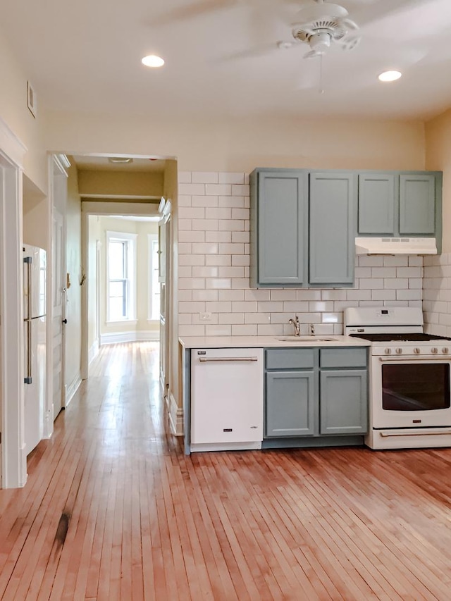 2641 W Thomas St, Chicago, IL 60622 - kitchen featuring white appliances, under cabinet range hood, gray cabinets, backsplash, and light wood-type flooring