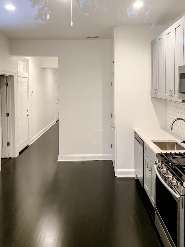 2641 W Thomas St, Chicago, IL 60622 - kitchen with appliances with stainless steel finishes, decorative backsplash, light countertops, dark wood-style flooring, and recessed lighting