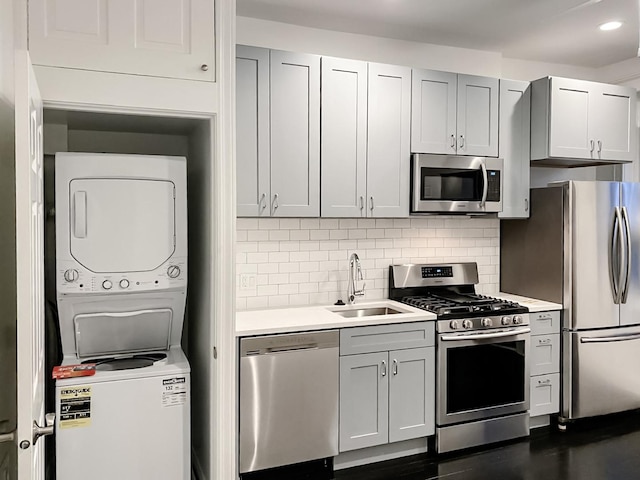 2641 W Thomas St, Chicago, IL 60622 - kitchen featuring appliances with stainless steel finishes, stacked washer / dryer, light countertops, decorative backsplash, and recessed lighting
