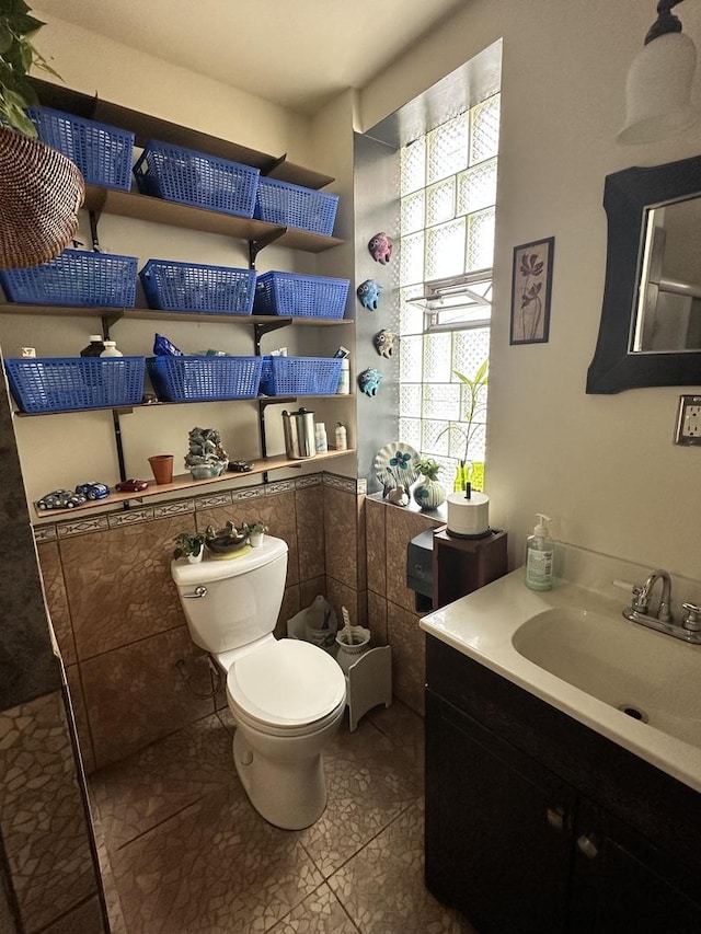 4440 W Iowa St, Chicago, IL 60651 - bathroom featuring vanity, tile walls, tile patterned floors, and a wainscoted wall
