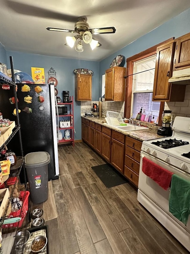 4440 W Iowa St, Chicago, IL 60651 - kitchen with white range with gas stovetop, freestanding refrigerator, dark wood-style floors, black microwave, and brown cabinetry