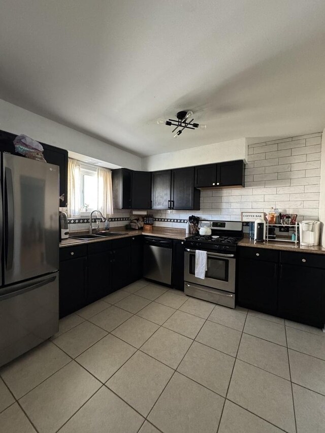 3712 W 121st St, Alsip, IL 60803 - kitchen featuring stainless steel appliances, dark cabinets, light tile patterned floors, and backsplash