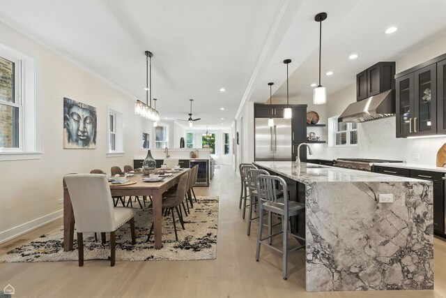 4525 N Artesian Ave, Chicago, IL 60625 - dining area with light wood-type flooring, ornamental molding, wine cooler, recessed lighting, and ceiling fan