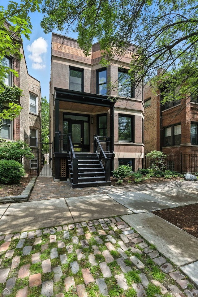 4525 N Artesian Ave, Chicago, IL 60625 - view of front facade with brick siding, a gate, and covered porch