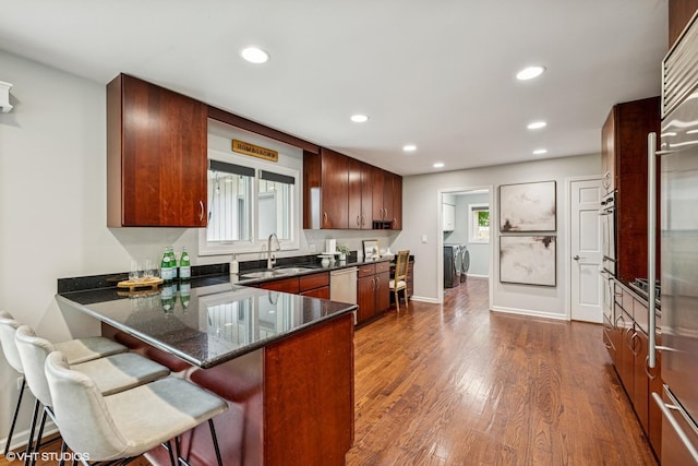 10 N Highview Cir, Hawthorn Woods, IL 60047 - kitchen featuring washing machine and dryer, recessed lighting, dark wood-style flooring, a peninsula, and a kitchen bar