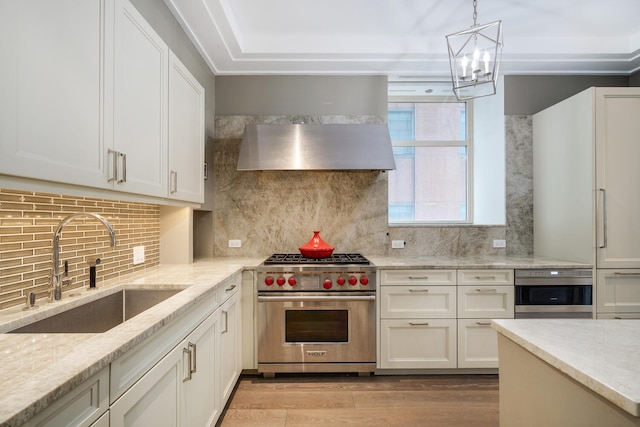 118 E Erie St Unit 21C, Chicago, IL 60611 - kitchen featuring high quality appliances, wall chimney range hood, light wood-type flooring, and white cabinetry