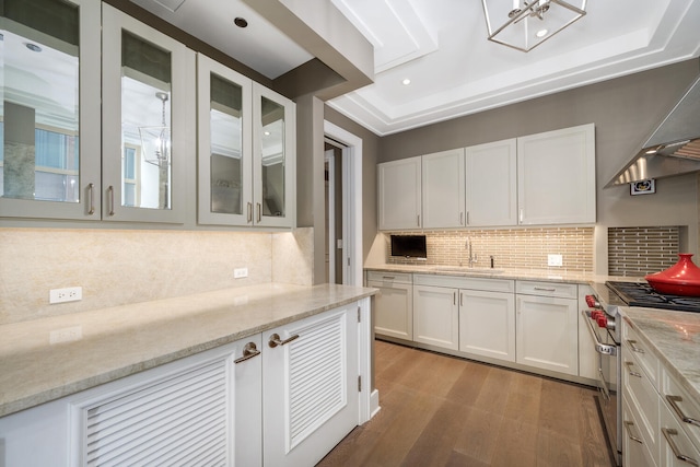 118 E Erie St Unit 21C, Chicago, IL 60611 - kitchen featuring high end range, wood finished floors, wall chimney range hood, white cabinetry, and recessed lighting