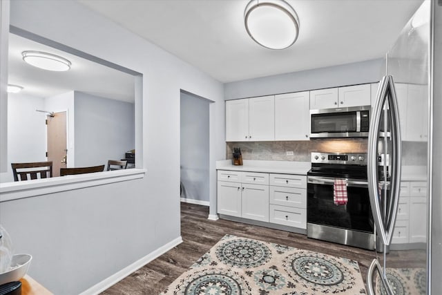 7502 Farmingdale Dr Unit 408, Darien, IL 60561 - kitchen with appliances with stainless steel finishes, white cabinetry, dark wood-style flooring, backsplash, and light countertops