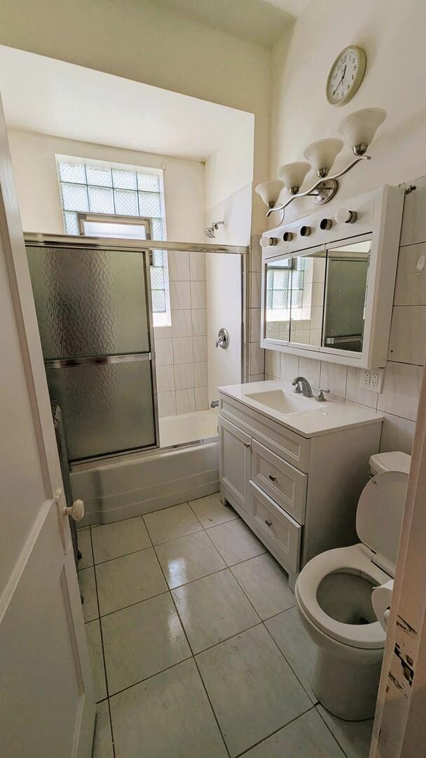 6240 S Kolmar Ave, Chicago, IL 60629 - bathroom with combined bath / shower with glass door, vanity, tile patterned flooring, and healthy amount of natural light