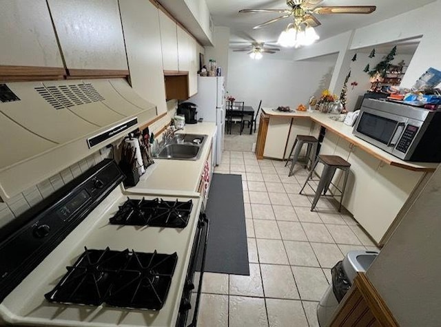 2086 Country Club Dr Unit 3F, Woodridge, IL 60517 - kitchen featuring white gas range oven, stainless steel microwave, a ceiling fan, light countertops, and light tile patterned flooring