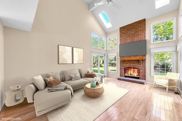 1175 Oxford Ct, Lake Zurich, IL 60047 - living area featuring a skylight, high vaulted ceiling, light wood-type flooring, a ceiling fan, and a brick fireplace