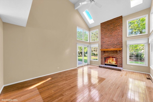 1175 Oxford Ct, Lake Zurich, IL 60047 - unfurnished living room with a skylight, high vaulted ceiling, ceiling fan, light wood finished floors, and a fireplace