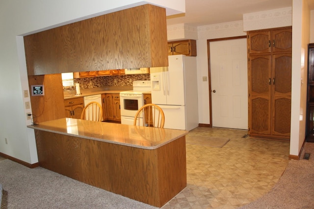 28 Manorhill Dr, Clinton, IL 61727 - kitchen featuring white appliances, a peninsula, brown cabinets, light countertops, and light floors