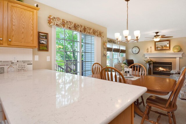 3115 Sable Oaks Rd, Bloomington, IL 61704 - dining space with healthy amount of natural light, a glass covered fireplace, ceiling fan, and a chandelier