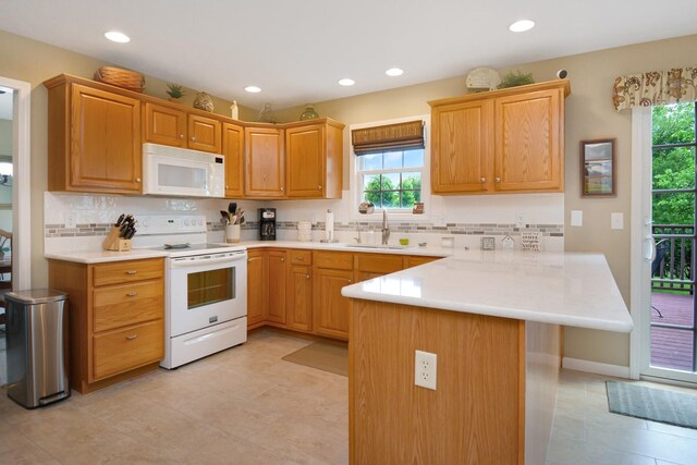 3115 Sable Oaks Rd, Bloomington, IL 61704 - kitchen featuring white appliances, a peninsula, healthy amount of natural light, tasteful backsplash, and recessed lighting