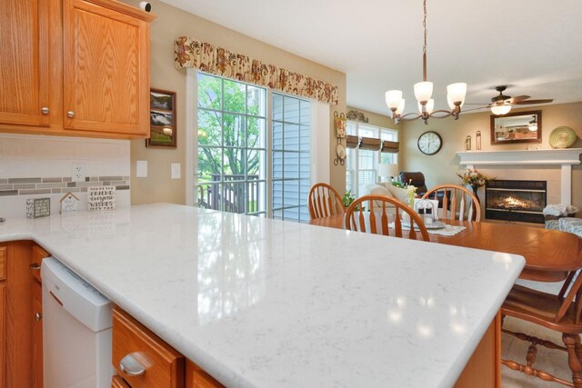 3115 Sable Oaks Rd, Bloomington, IL 61704 - kitchen with white dishwasher, open floor plan, plenty of natural light, and a glass covered fireplace