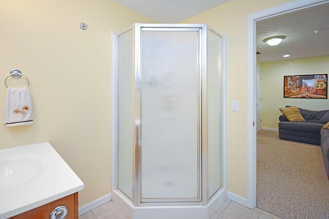 3115 Sable Oaks Rd, Bloomington, IL 61704 - ensuite bathroom featuring a shower stall, vanity, tile patterned floors, and a textured ceiling