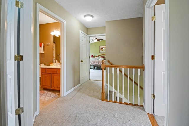 3115 Sable Oaks Rd, Bloomington, IL 61704 - hallway with light carpet, an upstairs landing, and a textured ceiling