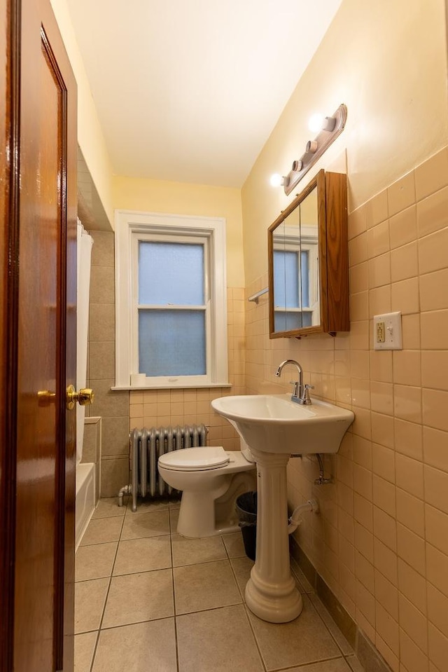 full bathroom with radiator heating unit, tile walls, and tile patterned flooring
