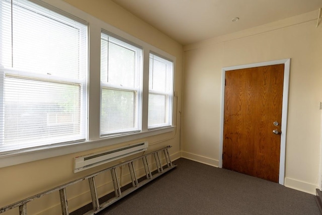 empty room featuring dark colored carpet and baseboards
