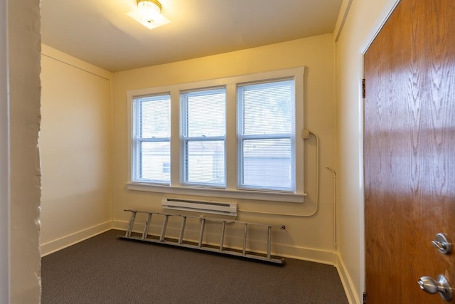 empty room featuring a wall mounted air conditioner and dark carpet