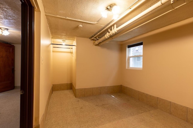 basement with a textured ceiling and tile patterned floors