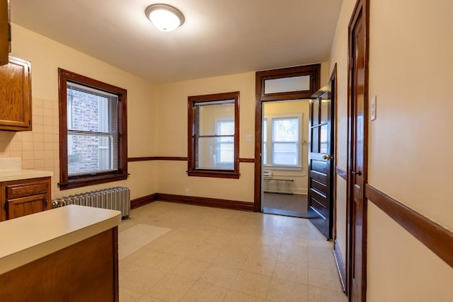 unfurnished dining area featuring radiator heating unit and light flooring
