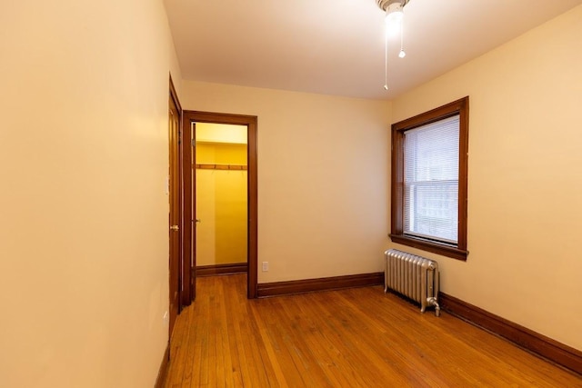 empty room featuring radiator and wood finished floors