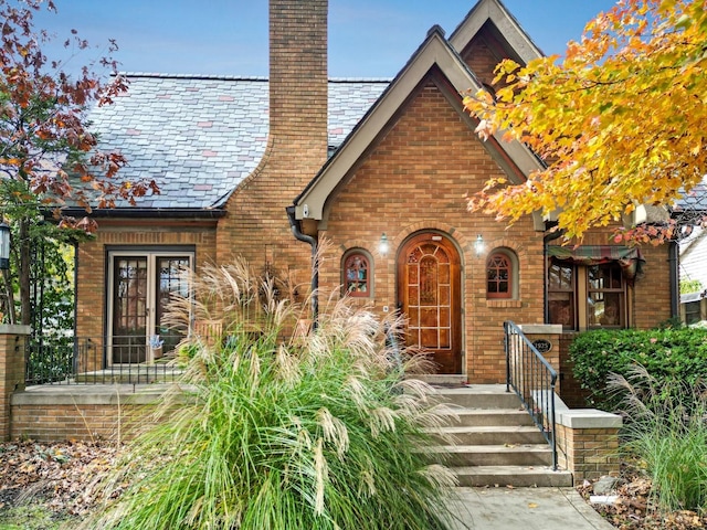 9 Harwood Pl, Bloomington, IL 61701 - tudor house with a high end roof, a chimney, and brick siding