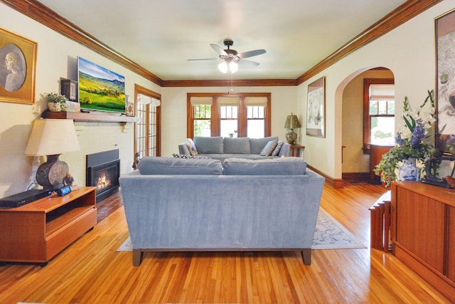 9 Harwood Pl, Bloomington, IL 61701 - living area with arched walkways, ceiling fan, a glass covered fireplace, light wood-style flooring, and crown molding