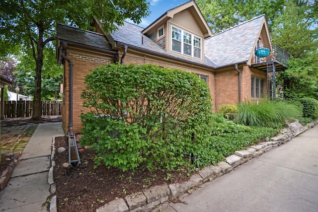 9 Harwood Pl, Bloomington, IL 61701 - view of home's exterior featuring a balcony, brick siding, and a high end roof