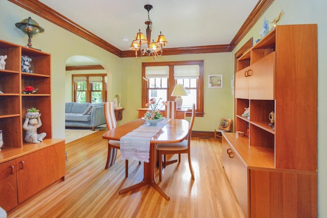 9 Harwood Pl, Bloomington, IL 61701 - dining room featuring light wood finished floors, a chandelier, crown molding, and arched walkways