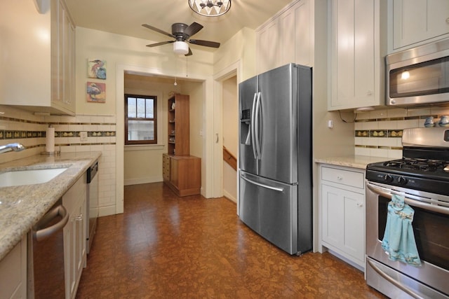 9 Harwood Pl, Bloomington, IL 61701 - kitchen with stainless steel appliances, dark floors, a ceiling fan, tasteful backsplash, and light stone counters