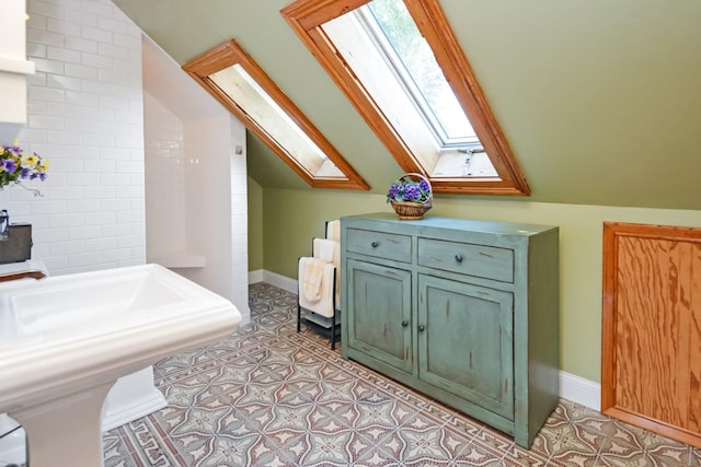 9 Harwood Pl, Bloomington, IL 61701 - bathroom featuring a skylight, vaulted ceiling, and tile patterned floors
