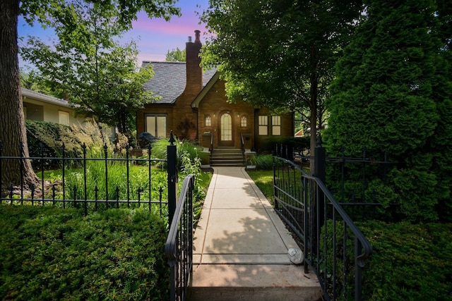 9 Harwood Pl, Bloomington, IL 61701 - tudor-style house with a fenced front yard, a chimney, a gate, and brick siding