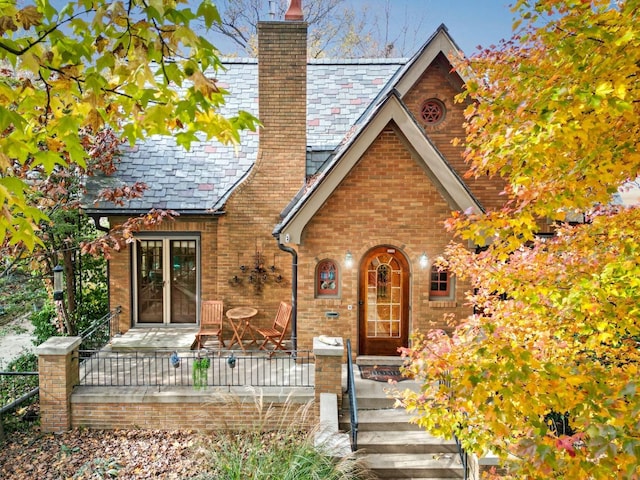 9 Harwood Pl, Bloomington, IL 61701 - tudor house featuring a chimney, a high end roof, and brick siding