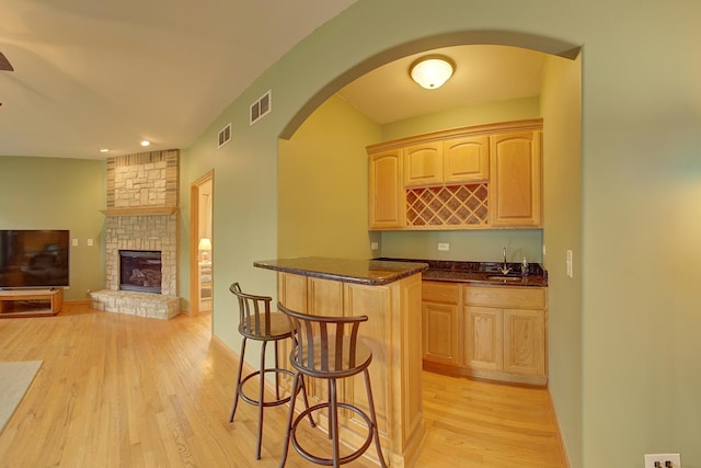 4914 W 82nd St, Burbank, IL 60459 - indoor wet bar with light wood finished floors, arched walkways, a fireplace, and recessed lighting