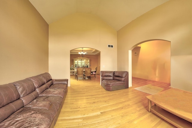 4914 W 82nd St, Burbank, IL 60459 - living area featuring arched walkways, wood finished floors, high vaulted ceiling, and a chandelier