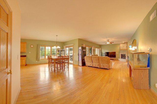 4914 W 82nd St, Burbank, IL 60459 - living area featuring light wood-type flooring, a fireplace, ceiling fan, and a chandelier