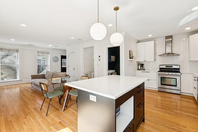 2118 W Schiller St Unit Ch, Chicago, IL 60622 - kitchen with stainless steel gas range oven, wall chimney exhaust hood, light wood finished floors, light countertops, and ornamental molding