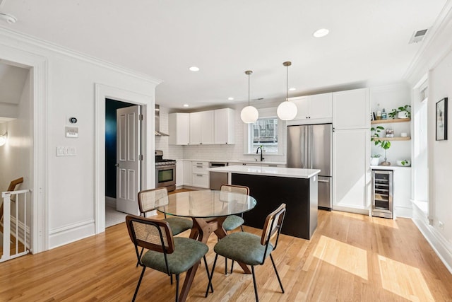 2118 W Schiller St Unit Ch, Chicago, IL 60622 - dining room featuring beverage cooler, light wood-style flooring, recessed lighting, and crown molding