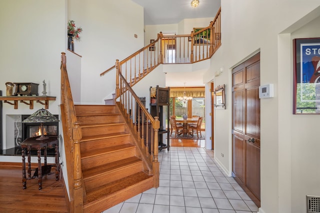 1304 Sheffield Ct, Carol Stream, IL 60188 - staircase with a chandelier, tile patterned flooring, and a towering ceiling