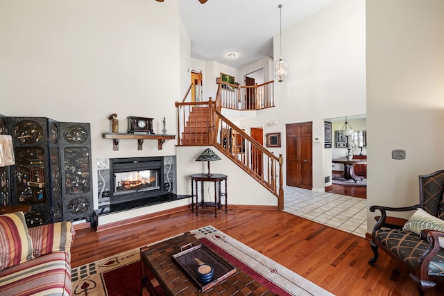 1304 Sheffield Ct, Carol Stream, IL 60188 - living room featuring stairway, wood finished floors, a multi sided fireplace, ceiling fan, and a towering ceiling